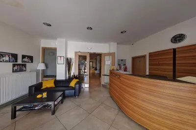 a living room with a couch and a kitchen at Hotel Bílý Páv in Benátky nad Jizerou