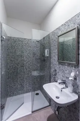 a bathroom with a glass shower and a sink at Hotel Bílý Páv in Benátky nad Jizerou