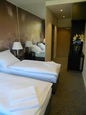 a hotel room with two beds and two lamps at Hotel Bílý Páv in Benátky nad Jizerou