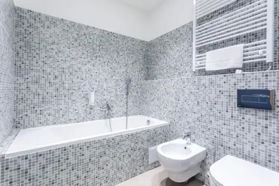 a bathroom with a tub and a toilet and a sink at Hotel Bílý Páv in Benátky nad Jizerou