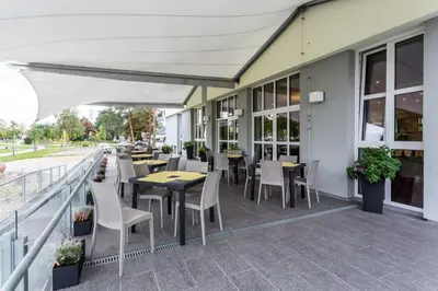 a restaurant with tables and chairs on a balcony at Hotel Bílý Páv in Benátky nad Jizerou