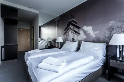 a bedroom with a large bed with white sheets at Hotel Bílý Páv in Benátky nad Jizerou