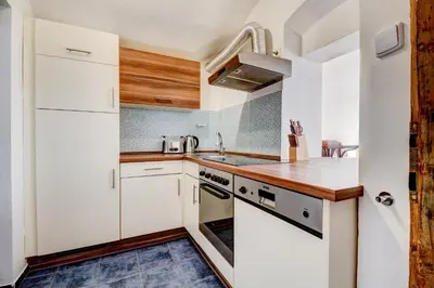 a kitchen with white cabinets and a sink at Studio Nicolas Prague in Prague
