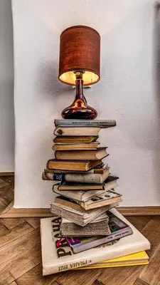 a lamp sitting on top of a stack of books at Studio Nicolas Prague in Prague