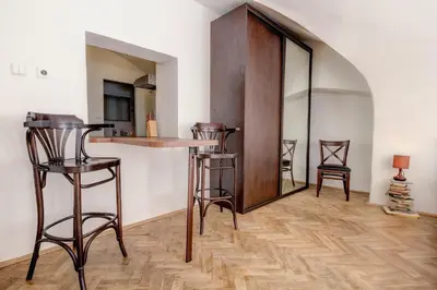 a bar in a room with stools and a mirror at Studio Nicolas Prague in Prague