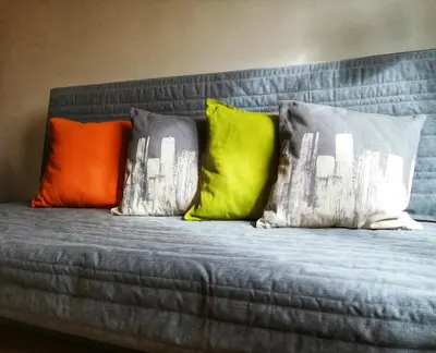 four colorful pillows sitting on a bed at Apartment Promenada in Poděbrady