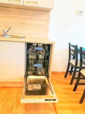 a dishwasher in the middle of a kitchen with two chairs at Apartment Promenada in Poděbrady