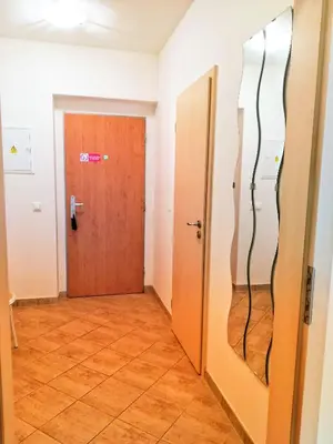 a room with a door and a hallway with wooden floors at Apartment Promenada in Poděbrady