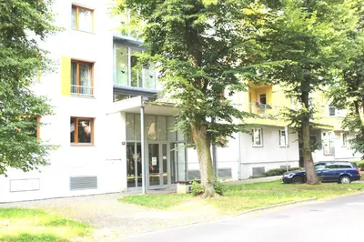 a white building with yellow windows on a street at Apartment Promenada in Poděbrady