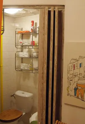 a bathroom with a toilet and a shelf above it at Prague Studio Old Town in Prague