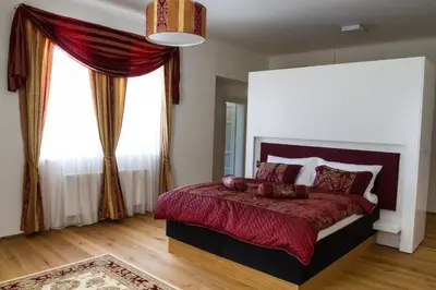 a bedroom with a large bed and a large window at Hotel Panství Dlouhá Lhota in Dlouhá Lhota