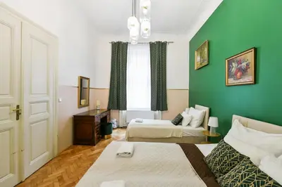 a room with two beds and a green wall at Stunning Charles Bridge Apartment in Prague