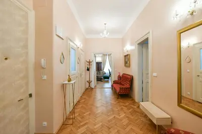 a hallway with a red chair and a mirror at Stunning Charles Bridge Apartment in Prague