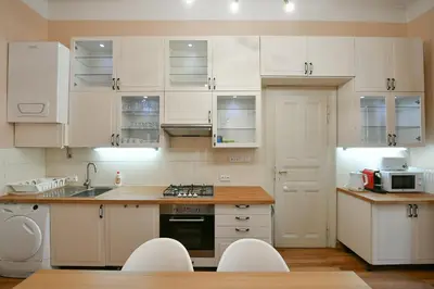 a white kitchen with white cabinets and a sink at Stunning Charles Bridge Apartment in Prague