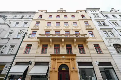 a large tan building with a red door at Stunning Charles Bridge Apartment in Prague