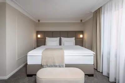 a bedroom with a large white bed and a chair at Mamma´s Boutique Hotel in Poděbrady