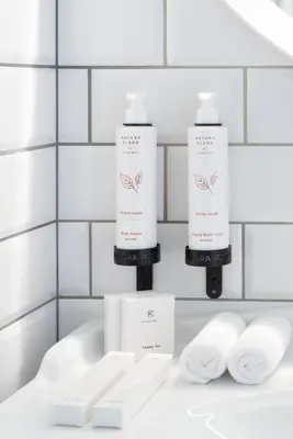 two bottles of shampoo and towels on a counter in a bathroom at Mamma´s Boutique Hotel in Poděbrady
