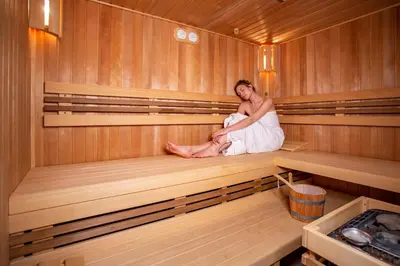 a woman is sitting in a sauna at Mamma´s Boutique Hotel in Poděbrady
