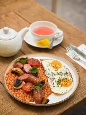 a plate of food with eggs and beans and a cup of tea at Mamma´s Boutique Hotel in Poděbrady