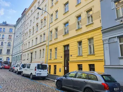 a yellow building with cars parked in front of it at Apartment in the center of Prague in Prague