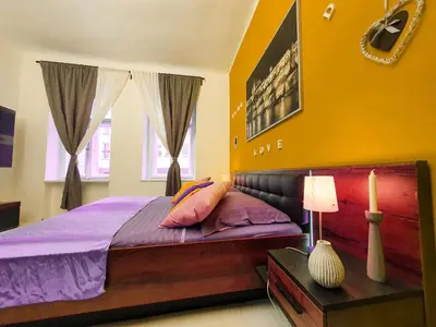 a bedroom with a large bed with purple sheets at Apartment in the center of Prague in Prague