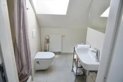 a white bathroom with a toilet and a sink at The Republic Apartments in Prague