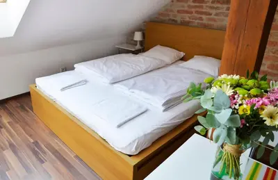 a bed in a room with a vase of flowers at The Republic Apartments in Prague