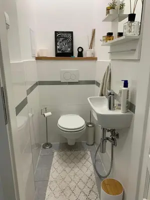 a white bathroom with a toilet and a sink at The Republic Apartments in Prague