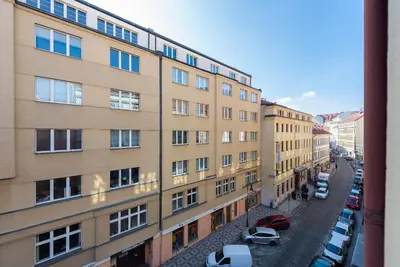 an apartment building with cars parked in a parking lot at Crystal Apartment in Prague