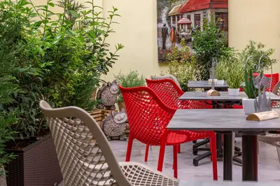 a group of red chairs and tables on a patio at Salvator Boutique Hotel vegan-friendly in Prague