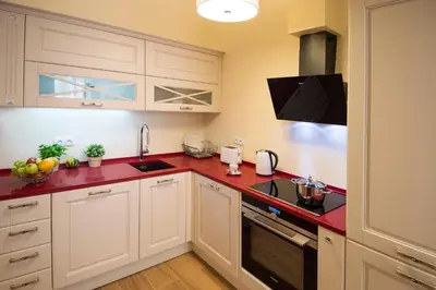 a kitchen with white cabinets and red counter tops at Apartment Za Poricskou branou in Prague
