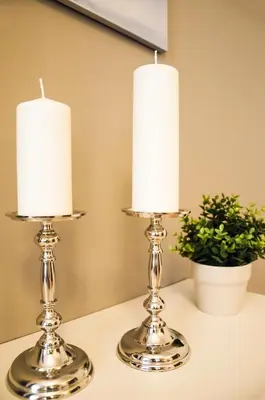 two silver candle holders on a table with a plant at Apartment Za Poricskou branou in Prague