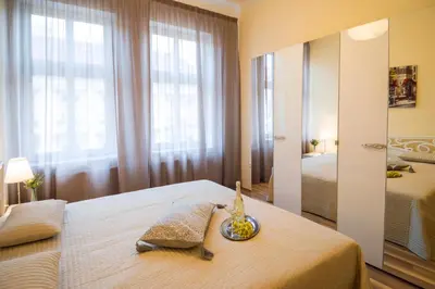 a bedroom with a bed with a mirror and a window at Apartment Za Poricskou branou in Prague