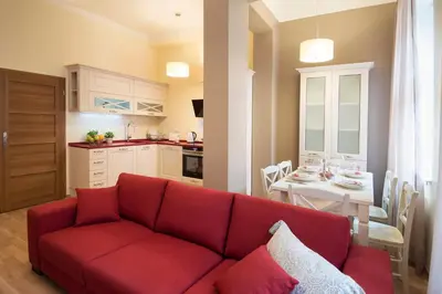 a living room with a red couch and a kitchen at Apartment Za Poricskou branou in Prague