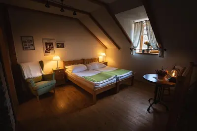 a bedroom with a bed and a chair and a window at Starý Svět in Wotitz