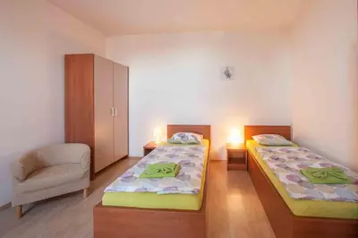 a room with two beds and a chair in it at Agropenzion U Bartousku in Malíkovice
