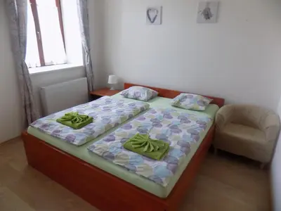 a small bedroom with a bed and a chair at Agropenzion U Bartousku in Malíkovice
