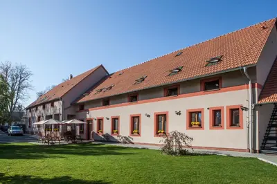 a building with a grass yard in front of it at Agropenzion U Bartousku in Malíkovice