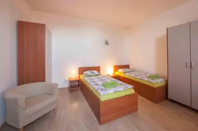 a room with two beds and a chair in it at Agropenzion U Bartousku in Malíkovice