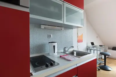a kitchen with red cabinets and a sink at Prague Letna Apartments in Prague