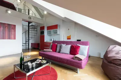 a purple couch in a living room with a staircase at Prague Letna Apartments in Prague