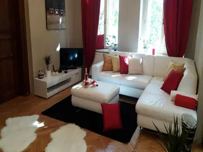 a living room with a white couch and red pillows at Family Flat 120m2, Praha 2 Vinohrady in Prague