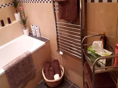 a bathroom with a tub and a basket of towels at Family Flat 120m2, Praha 2 Vinohrady in Prague