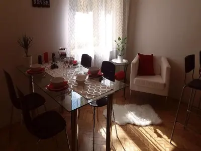 a dining table and chairs in a living room at Family Flat 120m2, Praha 2 Vinohrady in Prague