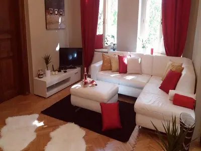 a living room with a white couch and red pillows at Family Flat 120m2, Praha 2 Vinohrady in Prague