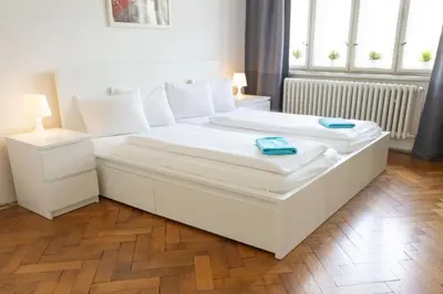 a large white bed in a room with a wooden floor at Apartments with 2 Bathrooms- 5 minutes from Old Town - 102 m2 in Prague