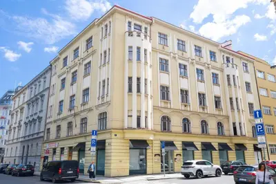 a large yellow building with cars parked in front of it at Apartments with 2 Bathrooms- 5 minutes from Old Town - 102 m2 in Prague