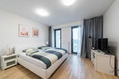 a bedroom with a large bed and a television at Garden Towers Apartments in Prague