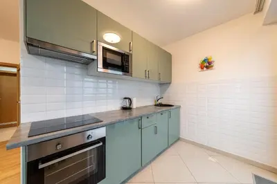 a kitchen with blue cabinets and a microwave at Garden Towers Apartments in Prague