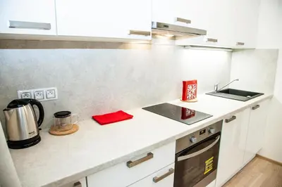 a kitchen with white cabinets and a sink and a stove at Garden Towers Apartments in Prague